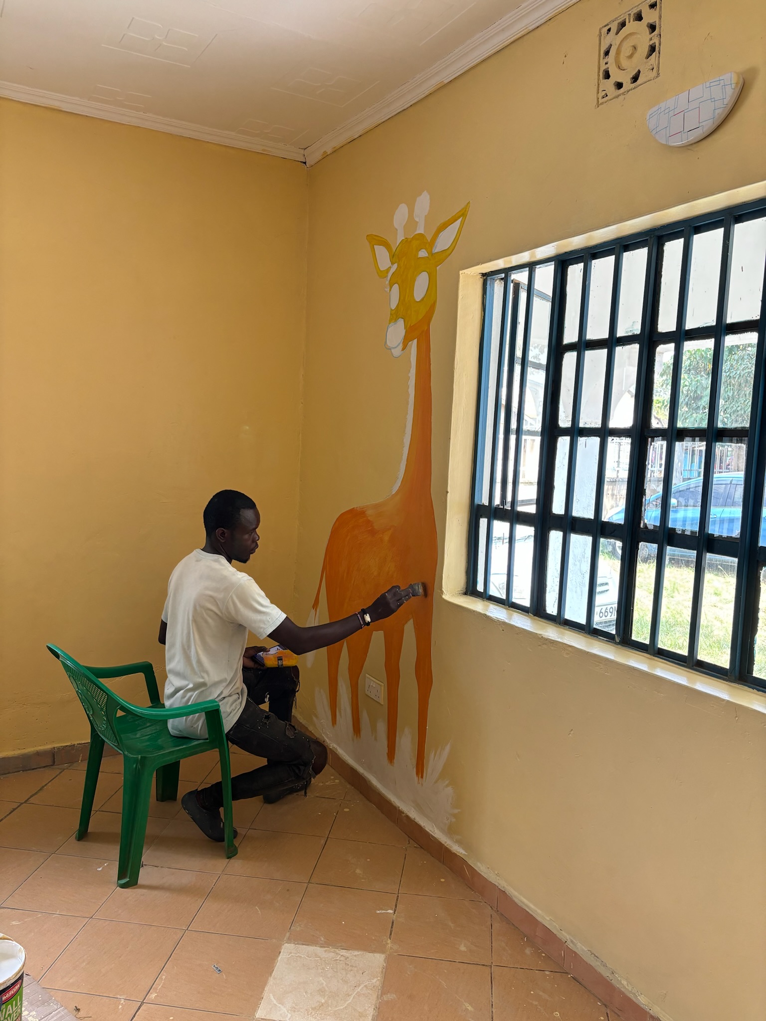 Local volunteer painting giraffe mural