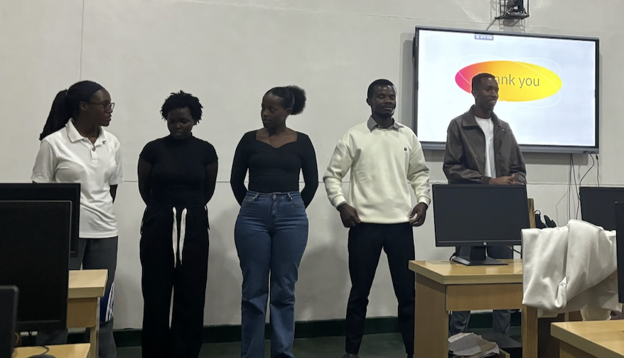 Five students standing in front of a screen at the end of their presentation